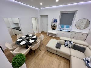 a living room with a couch and a table and chairs at Grand Apartment Piran in Piran