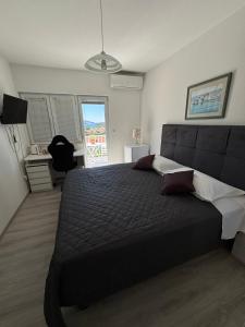 a bedroom with a large bed and a desk at Bjelopera Rooms in Zaton