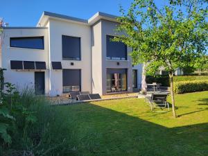 un gran edificio blanco con césped delante en Chambres d'hôtes dans maison contemporaine, en Vernouillet