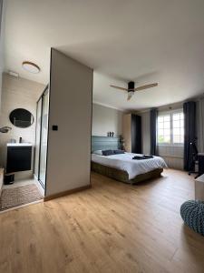 ein Schlafzimmer mit einem Bett und einer Glasschiebetür in der Unterkunft Oasis de Détente avec Piscine et Jacuzzi 300m2 in Roézé-sur-Sarthe