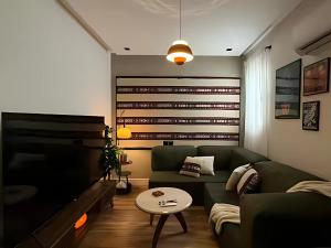 ein Wohnzimmer mit einer grünen Couch und einem Tisch in der Unterkunft ツ Najd Unit Luxe by KAFD in Riad