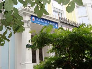 un bâtiment avec un panneau bleu sur son côté dans l'établissement Llandudno Hostel, à Llandudno