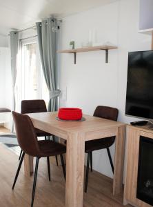 einen Esstisch mit Stühlen und einen TV in der Unterkunft Franz Josefs Tinyhäuser in Untergriesbach