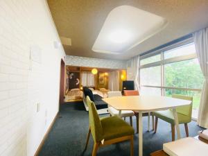 a living room with a table and chairs at 優中富良野 in Nakafurano