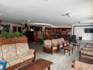 a living room with couches and tables and a tv at Hotel Fraiteve in Cesana Torinese