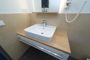 a white sink in a bathroom with brown tiles at Landhotel Hopster in Rheine +23 photos