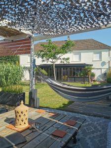 eine Hängematte im Hof mit einem Haus in der Unterkunft Oasis de Détente avec Piscine et Jacuzzi 300m2 in Roézé-sur-Sarthe