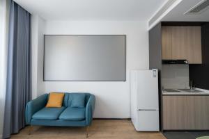 a blue couch in a kitchen with a white refrigerator at Le Chao Select Hotel in Shanghai +26 photos