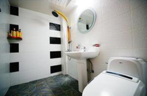 a bathroom with a white toilet and a sink at Gamyoungroo Hanok Hotel in Jeonju