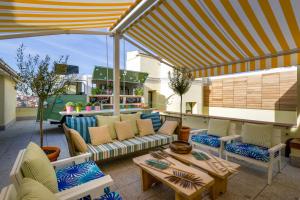 a patio with couches and tables and a bar at Vincci The Mint in Madrid