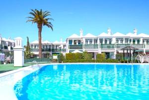 a large swimming pool in front of a large house at Paradise Tropical Sun Maspalomas in San Bartolomé