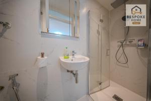 a white bathroom with a sink and a shower at Modern 4 Bed 3 Bath House - 4 Groups with FREE Parking - Central London in London +27 photos
