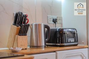 a kitchen counter with a knife block and utensils at Modern 4 Bed 3 Bath House - 4 Groups with FREE Parking - Central London in London