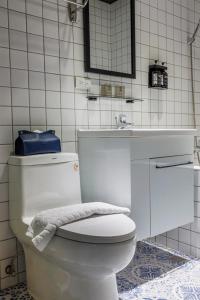 a bathroom with a white toilet and a sink at Meng Yun Ge Hotel in Jiaoxi
