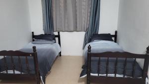 two twin beds in a room with a window at Homestay H&H in Cyberjaya