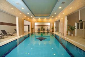 a large swimming pool in a building with a pool at Darin Plaza Hotel in Erbil