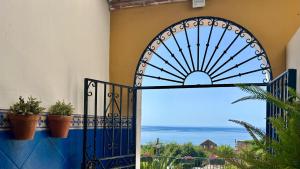 an iron gate with a view of the ocean at Apartamentos Balcón de Maro in Maro