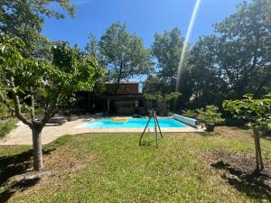 a swimming pool in a yard with a rainbow at Le Mimosa in Nans-les-Pins