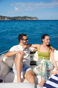 a man and woman sitting on a boat in the water at Mallorcainblue Charter in Port d'Alcudia +2 photos