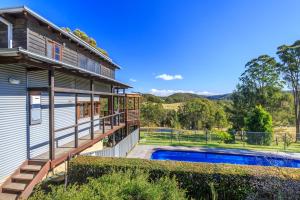 uma casa com um deque e uma piscina em Goosewing Cottage em Mount View