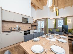 kuchnia i jadalnia z drewnianym stołem i krzesłami w obiekcie Luxury Chalet in Saalbach-Hinterglemm with Sauna w Saalbach Hinterglemm