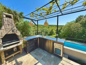 a patio with an outdoor bar and an outdoor grill at Villa Theresa in Donji Zagon