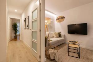パンプローナにあるPrecioso apartamento recién reformado pleno centroのソファと薄型テレビのあるリビングルーム