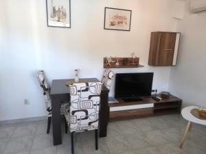 un soggiorno con scrivania e TV di Petrovic apartmani a Tivat