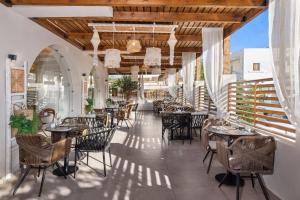 a restaurant with tables and chairs on a patio at Cabana White Boutique Hotel in Kardamaina