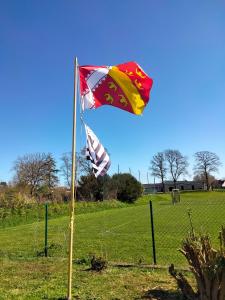 Dos banderas en un mástil junto a una valla en Alsabreizh bihan kalon harzala, en Lanvollon