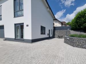 a white house with a brick driveway at Auszeit in der Vulkaneifel in Üdersdorf
