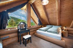 a bedroom in a log cabin with a bed and a table at Bándi Kuckó in Bánd