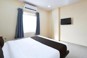 une chambre avec un lit blanc et une fenêtre dans l'établissement Townhouse VSK group of hotels, à Hyderabad