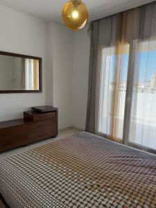 a bedroom with a bed with a dresser and a mirror at S2 meilleur emplacement à jardin l'aouina in El Aouina