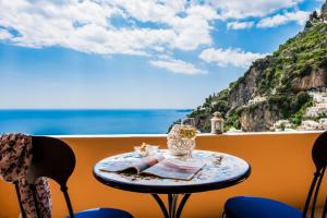 a table on a balcony with a view of the ocean at Villa Setteventi in Positano