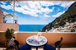 a table and chairs on a balcony with a view of the ocean at Villa Setteventi in Positano +57 photos