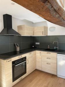 a kitchen with wooden cabinets and a stove top oven at Peaceful countryside loft in Saonnet +12 photos