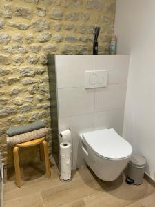 a bathroom with a white toilet and a stool at Peaceful countryside loft in Saonnet