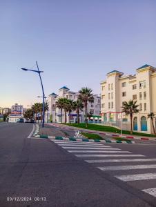 una strada vuota in una città con palme ed edifici di Maison à fnideq face de Ceuta a Fnidek