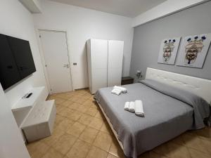 a bedroom with a bed with two towels on it at Naxos Sweet Dreams Apartment in Giardini Naxos