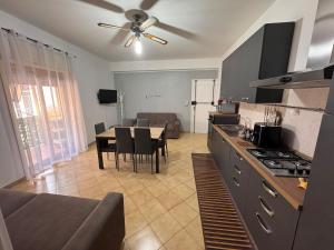a kitchen and living room with a table and a couch at Naxos Sweet Dreams Apartment in Giardini Naxos