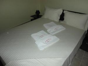 a white bed with two towels on top of it at diakopto free in Mesochórion