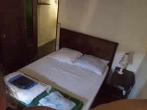 a bedroom with a bed with white sheets and pillows at Maison de village avec jardin in Saint-Louis-et-Parahou