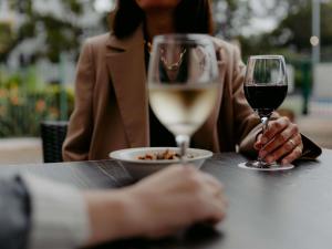 悉尼悉尼帕拉马塔美居酒店的两人坐在桌子旁,喝一杯葡萄酒