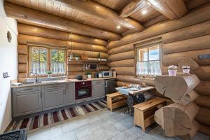 a kitchen with wooden walls and a wooden ceiling at Bándi Kuckó in Bánd