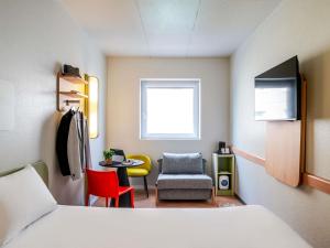 ein Zimmer mit einem Bett, einem Stuhl und einem Tisch in der Unterkunft Ibis Budget Bilbao Barakaldo in Barakaldo