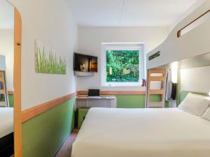 ein Schlafzimmer mit einem Bett, einem Schreibtisch und einem Fenster in der Unterkunft Ibis Budget Bilbao Barakaldo in Barakaldo