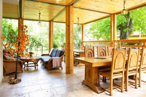 a wooden conservatory with a wooden table and chairs at Casa Decebal in Băile Herculane