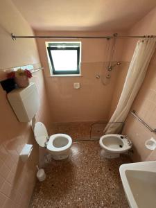un baño con inodoro y lavabo en Villa Pineta - Parcheggio, Giardino, Wi-Fi, Tavolo Ping Pong - Oasi di Tranquillità a Due Passi dal Mare, en Lignano Sabbiadoro 37 fotos más
