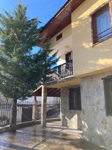 a house with a tree in front of it at Къща за гости Рупчос 1 in Smolyan